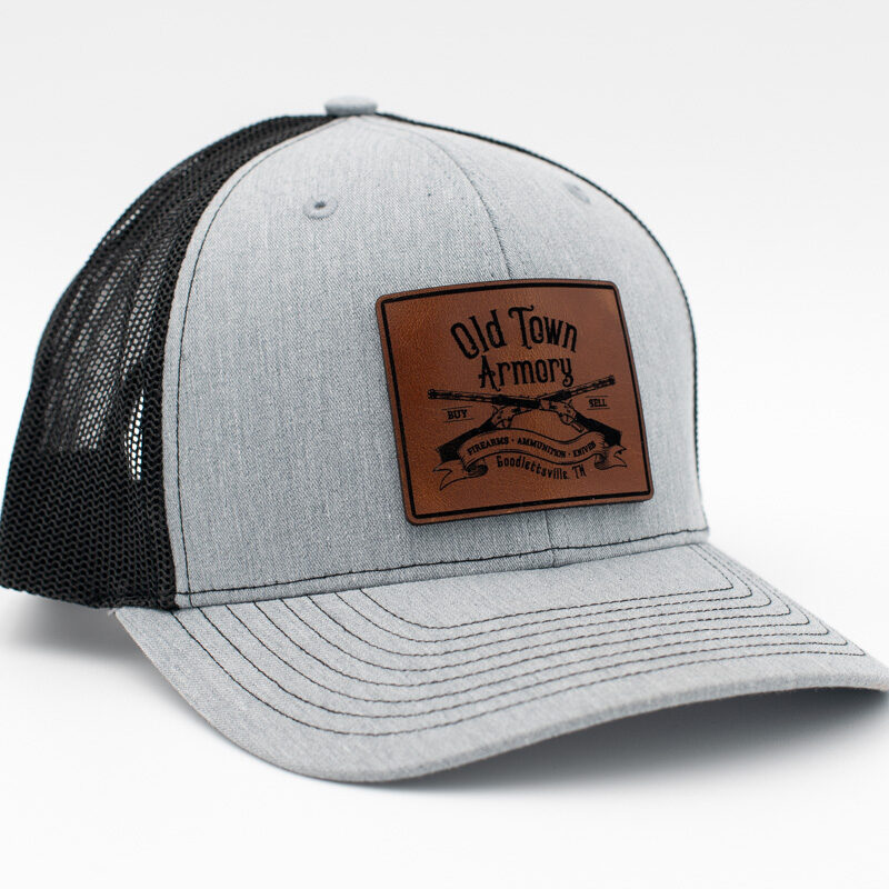 Gray and black baseball cap with a brown patch on the front reading "Old Town Armory" and featuring a rifle graphic.