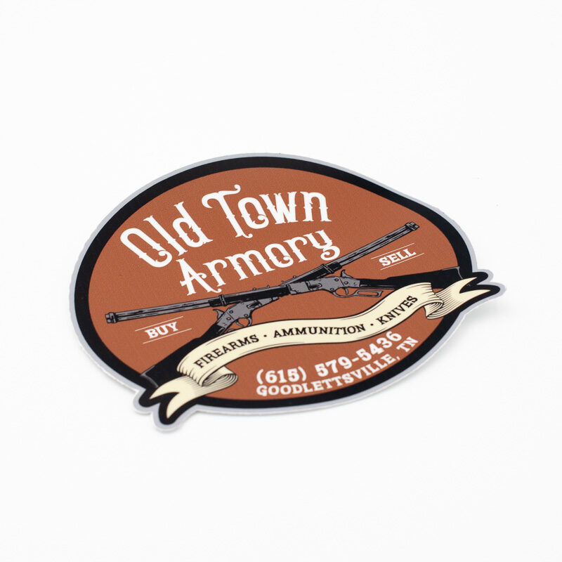 A round sticker with "Old Town Armory" in stylized text. Below, it says "Firearms, Ammunition, Knives." The address is in Goodlettsville, TN, with a phone number provided. Two crossed rifles are pictured.