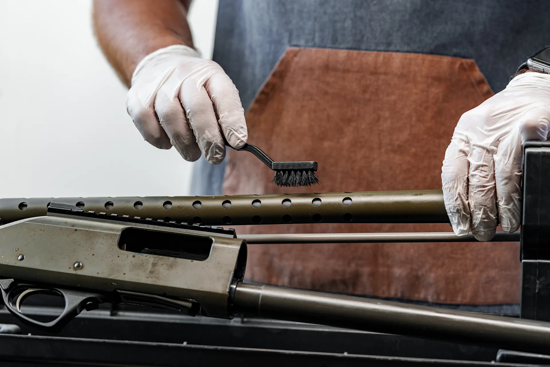 Gunsmith professionally cleaning a rifle